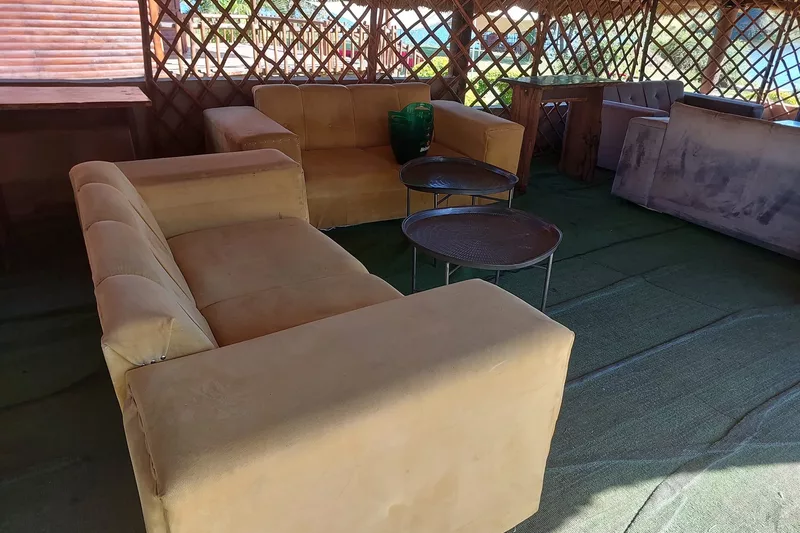 Couches under a thatched roof at Refilwe Farm Resort in Tzaneen