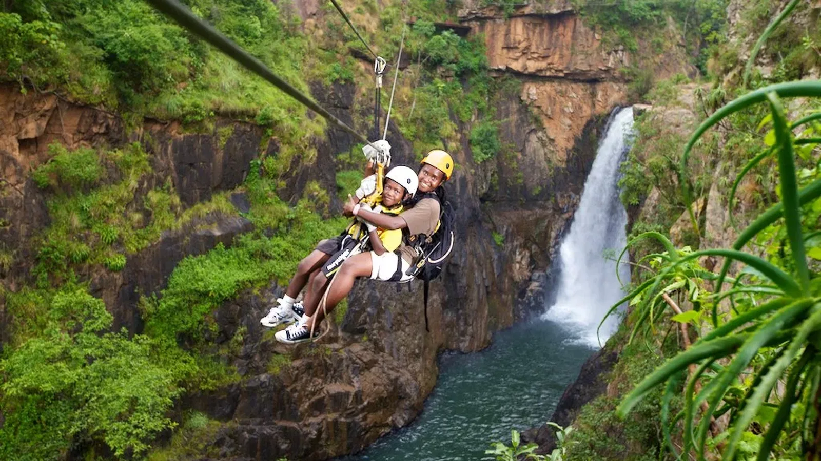 Two young tourists zip lining Magoebaskloof canopy tours in Tzaneen