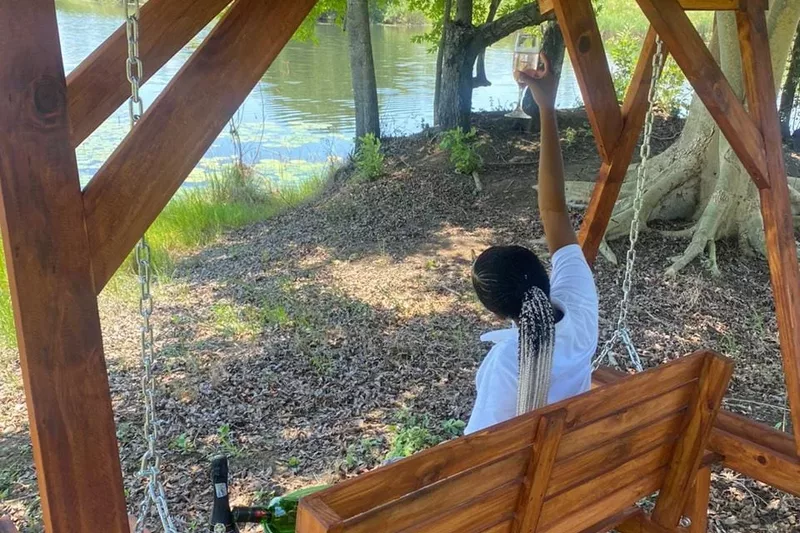 Back view of a tourist sitting on a wooden chair looking at a dam at Refilwe Farm Resort in Tzaneen